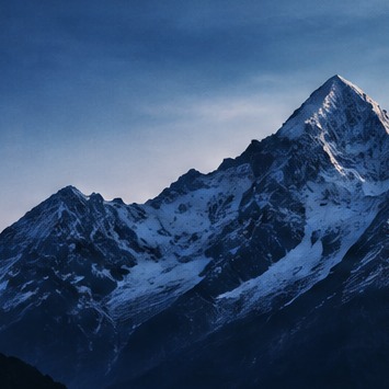 Snow-covered mountains under a blue evening sky